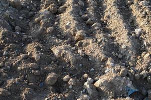 sand lies in the center of city at a  site. construction vehicles are driving on the sand for the construction complex. footprints in the sand from the car are strewn with white small stones photo