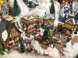 New Year's landscape. miniature for the showcase. small houses with triangular roofs and toy people in the center. mini city before Christmas. winter wonderful night photo