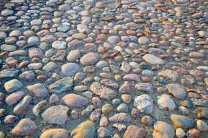 la textura del camino de piedra, pavimento, paredes de grandes piedras grises redondas medievales antiguas, adoquines. el fondo foto