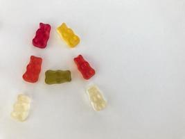letra a hecha de hermosos y deliciosos dulces de osos gomosos de frutas jugosas masticables multicolores sobre un fondo blanco. dulce alfabeto foto
