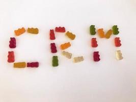 word from gummy gummy bears. edible letters C, R M. vitamin word. English alphabet. delicious appetizing dessert. unusual image of automated accounting photo