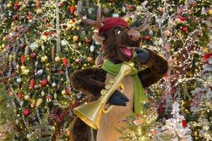 decoración navideña para un centro comercial. en el centro hay un ciervo tocando el saxofón. ciervos tocando canciones navideñas. las ramas de abeto están decoradas con cuentas y bolas de colores foto