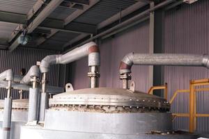 Stainless steel metal lid with bolts and studs, top of the heat exchanger of a chemical rectification column with a pipe with flanges at an industrial refinery petrochemical plant photo