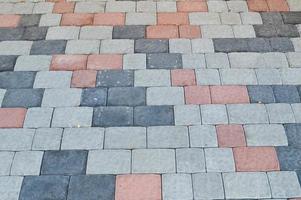 Texture of gray rectangular concrete stone paving slabs on the road with seams. The background photo