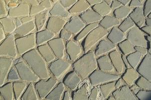 la textura del camino de piedra, pavimento, paredes de grandes piedras grises redondas medievales antiguas, adoquines. el fondo foto