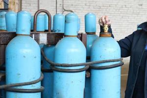 Large iron metal blue gas cylinders with oxygen, air, helium under excessive internal pressure to store compressed, liquefied and dissolved under pressure gases photo
