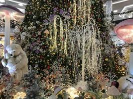 christmas decorations. a toy polar bear stands next to an artificial Christmas tree. mother bear holds her cub in her arms. next to her are colorful mushrooms. christmas eve cute toys for kids photo