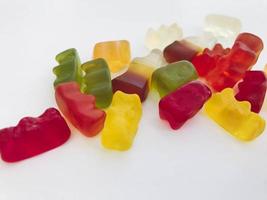 gummy candy on a white matte background. marmalade in the form of gelatinous bears lies on the table. voluminous, non-uniform sweets for dessert made from natural fruits and nectars photo