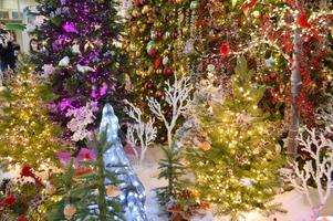 Christmas theme. Young beautiful European girl on a background of a Christmas tree, lights and toys in a joyful mood, happy photo