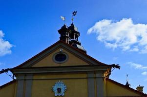 Tall steeples and towers, the roof of an old, ancient medieval baroque castle, a renaissance, Gothic in the center of Europe against a blue sky photo