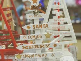 Wooden beautiful toy decorative Christmas cute festive Christmas trees with inscriptions of happy Christmas, Santa is coming. The background photo