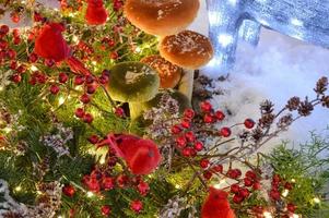 champiñones y bayas rojas en nieve y escarcha sobre un fondo azul. imagen artistica de navidad foto