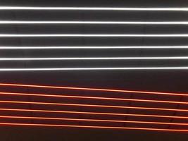 Abstract festive vertical background with red, orange and white LED stripes on a black background for design on the theme of Christmas, New Year, disco style, EDM photo