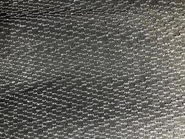 Texture of black synthetic fabric with beautiful silvery dots sparkles. The background photo