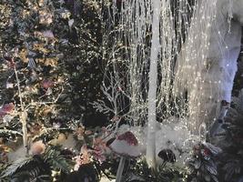 New Year's decorations for the shopping center. artificial Christmas trees covered with snow. polar bears in a snowdrift. next to them are tall multi-colored mushrooms and illumination photo