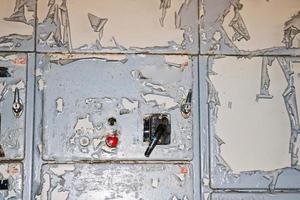 The power button and knob toggle switch to control industrial equipment at the factory on the background of a wall with shabby cracked paint photo