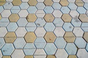 Texture of gray rectangular concrete stone paving slabs on the road with seams. The background photo