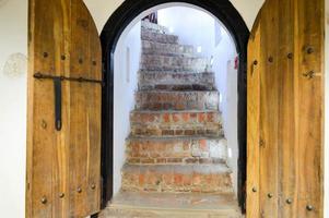 textura de la antigua puerta gruesa natural de madera resistente medieval antigua con remaches y patrones de clavos y cerraduras hechas de tablones de madera. el fondo foto