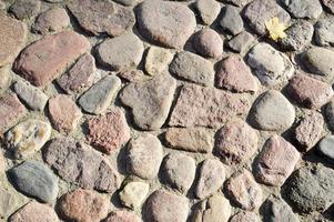 la textura del camino de piedra, pavimento, paredes de grandes piedras grises redondas medievales antiguas, adoquines. el fondo foto