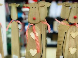 Little beautiful Christmas toy decorative wooden cute festive New Year's deer with red noses. The background photo