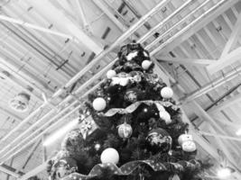 árbol de navidad verde festivo hermoso y elegante con bolas para el nuevo año en el fondo del techo con tubos de ventilación de metal en el estilo loft. concepto de navidad en una planta industrial foto