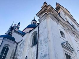 Old ancient white poor stone shabby Christian Orthodox church with crosses photo