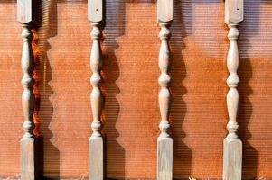 Wooden beautiful carved figured legs, sticks, columns on the background of brown plexiglass photo