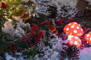 decoración navideña para un centro comercial. lindas setas amanita con luces adentro. crear un estado de ánimo de año nuevo para las visitas a la tienda. lindas ramas de abeto en el centro foto