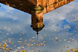 Reflection in the water of an old, ancient medieval castle in the center of Europe with towers and spiers. The background photo