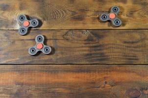A rare handmade wooden fidget spinners lies on a brown wooden background surface. Trendy stress relieving toys photo