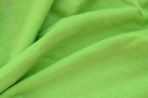 The texture of the fabric is bright green. Material for making shirts and blouses photo