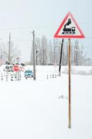 cruce ferroviario sin barrera con muchas señales de advertencia en la temporada de invierno con nieve foto