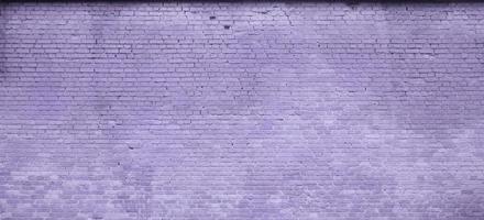 The texture of the brick wall of many rows of bricks painted in violet color photo