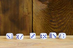 A few dice lies on the surface of natural wood. Items for generating numbers from one to six in the form of points that are painted on the side of cubes. The concept of gambling photo