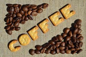 Coffee. The word from the edible letters lies on the gray canvas with coffee beans photo