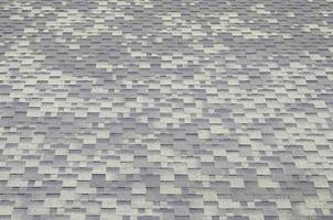 Background mosaic texture of flat roof tiles with bituminous coating photo