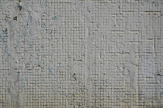 The texture of the old concrete wall, with a coating of shallow tiles of square shape, painted in gray. Background image of a wall of many square white tiles photo