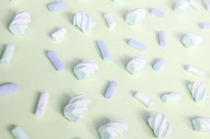 Colorful marshmallow laid out on lime paper background. pastel creative textured pattern photo