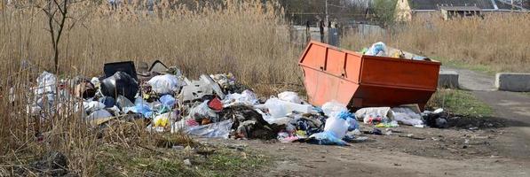 The garbage can is packed with garbage and waste. Untimely removal of garbage in populated areas photo