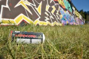 KHARKOV, UKRAINE - DECEMBER 9, 2020 Used Montana hardcore aerosol spray can against graffiti paintings. MTN or Montana-cans is manufacturer of high pressure spray paint goods photo