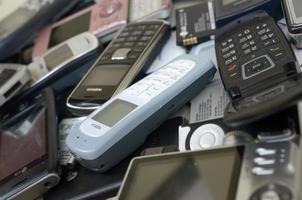 KHARKOV, UKRAINE - DECEMBER 9, 2020 Bunch of old used outdated mobile phones and batteries. Recycling electronics photo