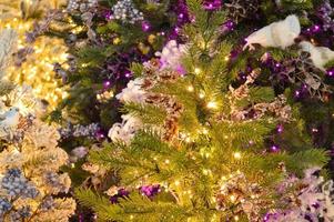 Texture of wall decorated with garlands and green pine fir branches, Christmas decorations background photo