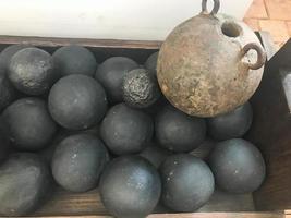 Texture of old antique combat round gray metallic, iron, stone cannon balls, ammunition. The background photo