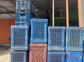 grandes cajas de plástico multicolores para productos y productos se colocan como una pared en un almacén foto