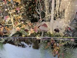 decoraciones de año nuevo para el centro comercial. árboles de navidad artificiales cubiertos de nieve. en un ventisquero osos de nieve, ardillas y hurones. junto a ellos hay hongos multicolores altos foto