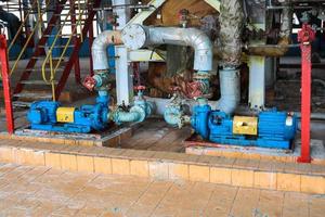 Iron metal centrifugal pumps equipment and pipes with flanges and valves for pumping liquid fuel products at the industrial refinery chemical petrochemical plant shop photo