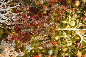 Christmas wreath of coniferous branches with cones and red berries and a garland of lights. Holiday, happy photo