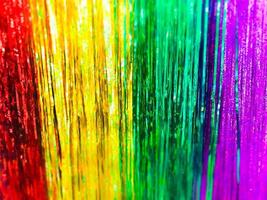 Festive multicolored rainbow shiny silver beautiful Christmas plastic garland sparkling for the New Year, Christmas-tree tinsel, festive decorated with a blur effect. Texture. Background photo