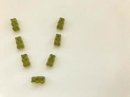 creative edible letter V made from gummy bears. Letter made from green gelatinous candies. unusual letter, making a word from sweets. marmalade treat photo