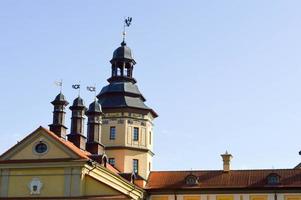altos campanarios y torres, el techo de un antiguo castillo barroco medieval, un renacimiento, gótico en el centro de europa contra un cielo azul foto